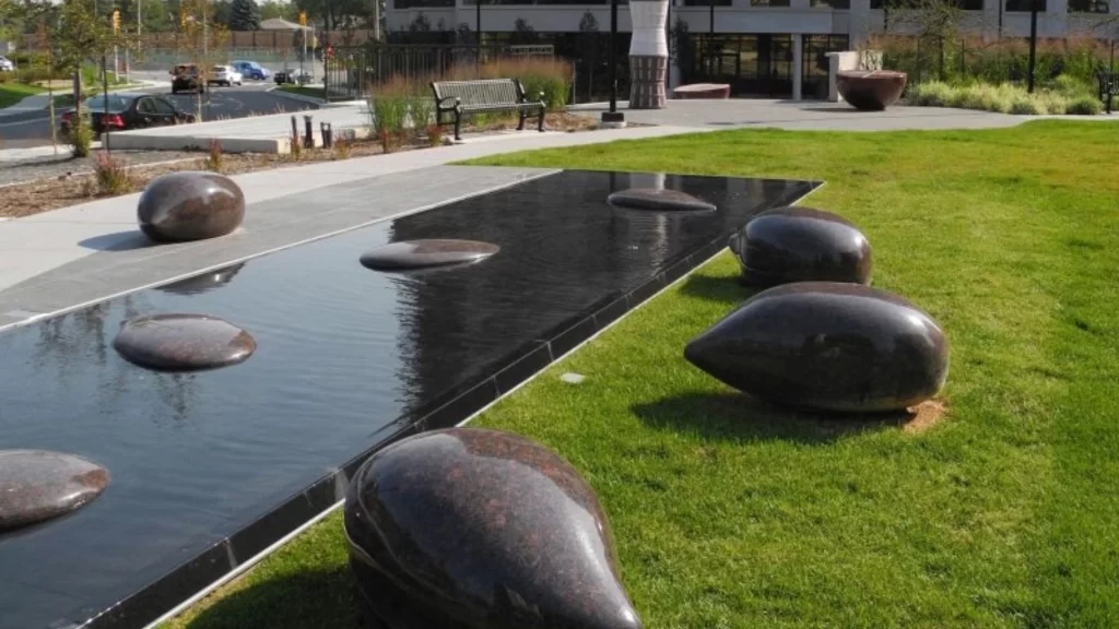 Large abstract granite shapes and water feature with a pond