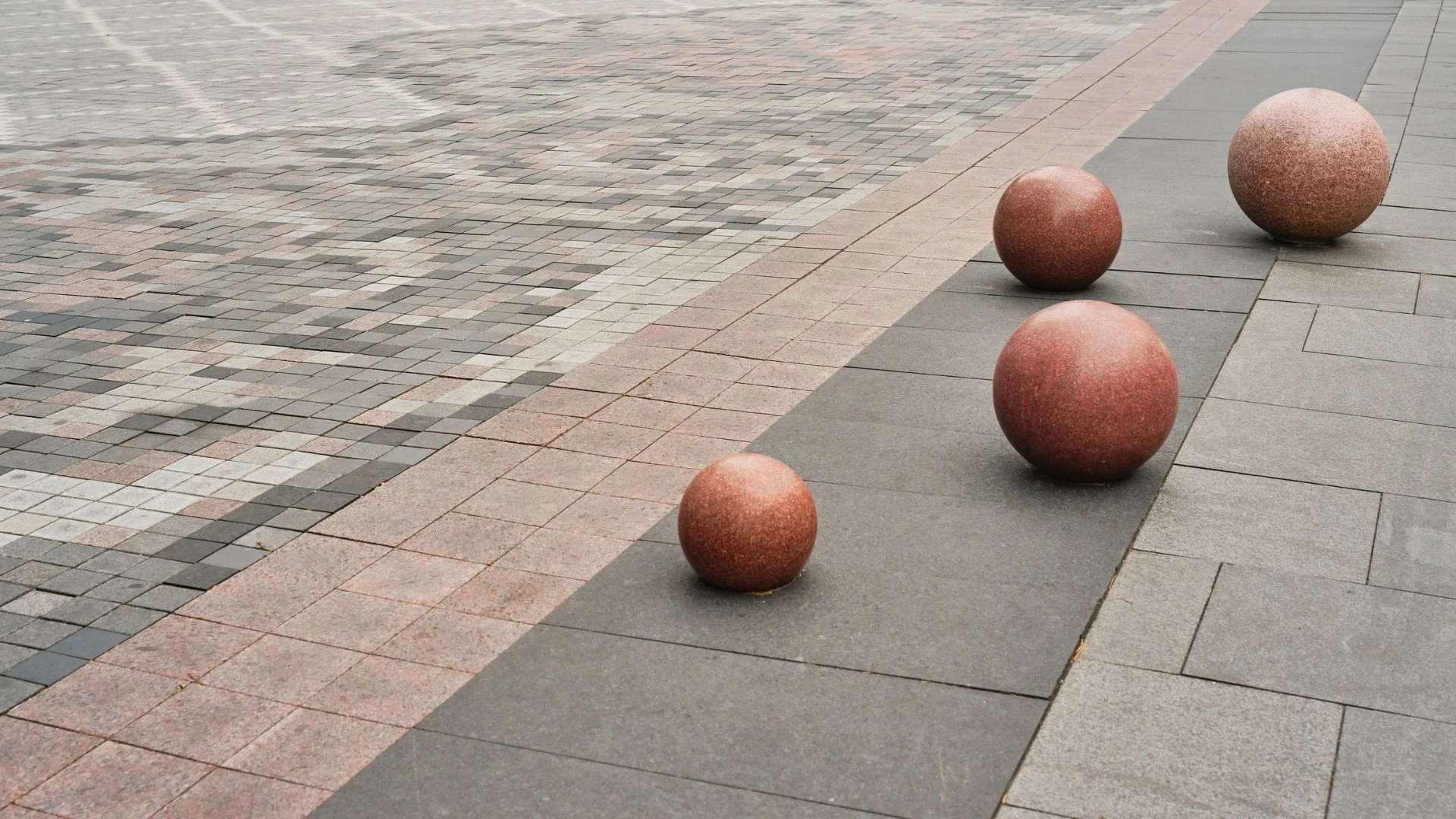 Round, red granite bollards at the Four Seasons parking entrance